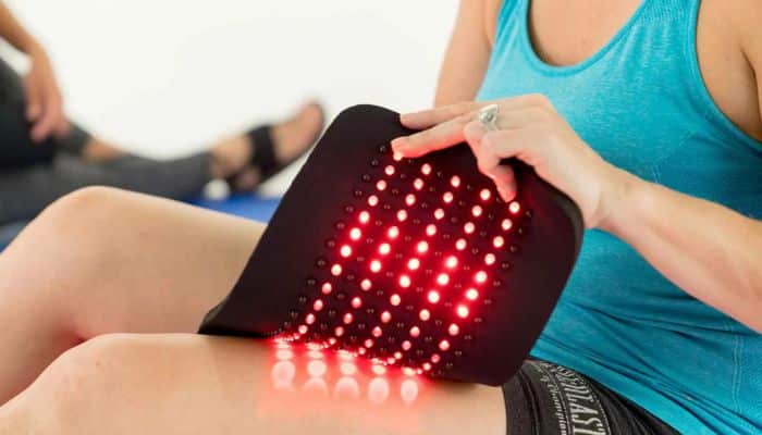 What Does Science Say About Red-Light Therapy for Tendon Pain - Startup Stride Halsten Stride Reviews 2026 showing a red-light therapy device being used on the hip area for pain relief, mobility support, and gluteal tendinopathy management